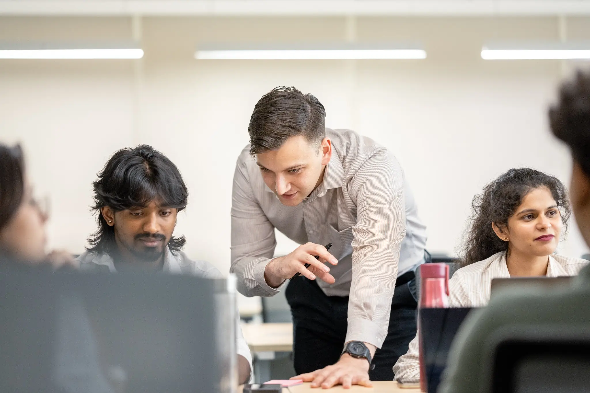 Julius kijkt mee over de schouder van een developer in Bangalore